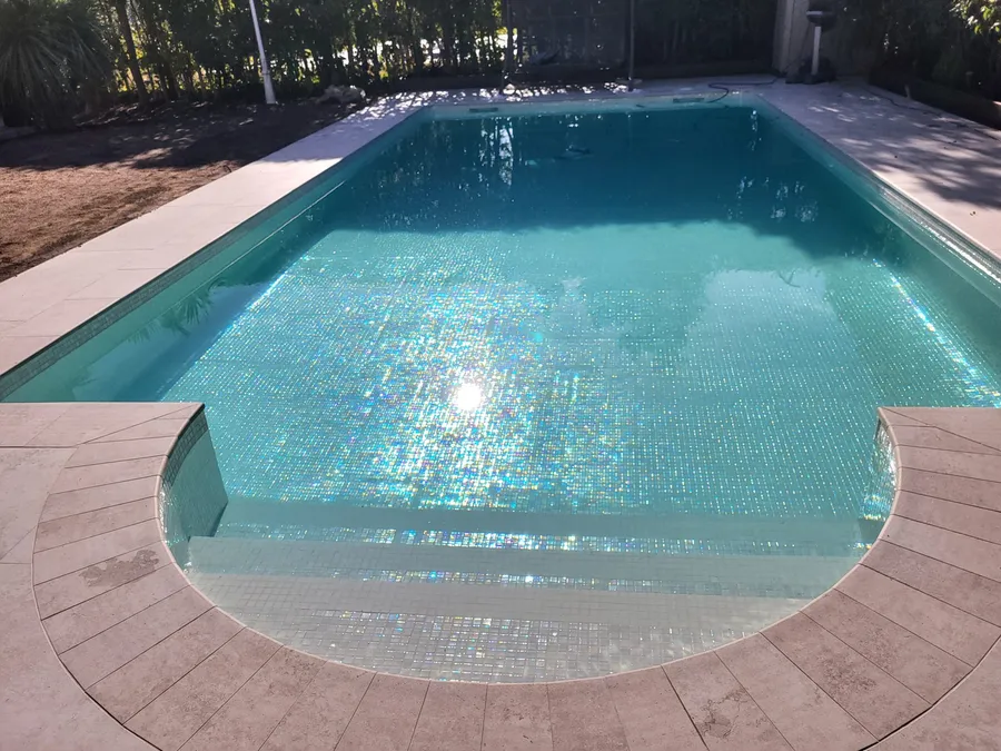 Piscina de gresite recién terminada, con escalera de acceso en curva