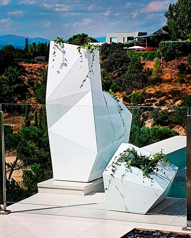 Monolito de piedra en un jardín de grava y gramíneas